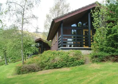 a house with a large window on the side of it at Lochearnhead Loch Side in Lochearnhead