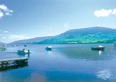 a group of boats on a large body of water at Lochearnhead Loch Side in Lochearnhead