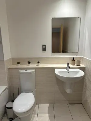 a bathroom with a toilet and a sink and a mirror at Pier House in Edinburgh