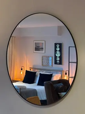 a mirror reflecting a bedroom with a bed at Pier House in Edinburgh