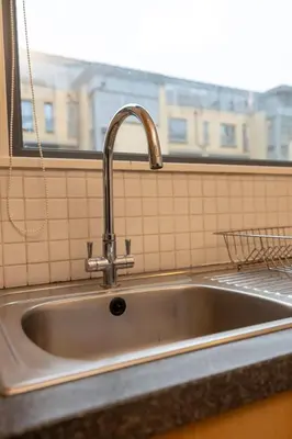 a stainless steel sink in a kitchen with a window at Muirhouse 2BR Apartment with Free Parking in Glasgow