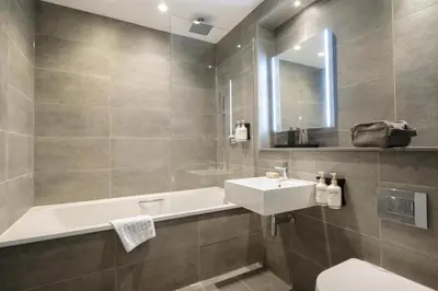 a bathroom with a sink and a bath tub at The Wellington Glasgow by Adina in Glasgow