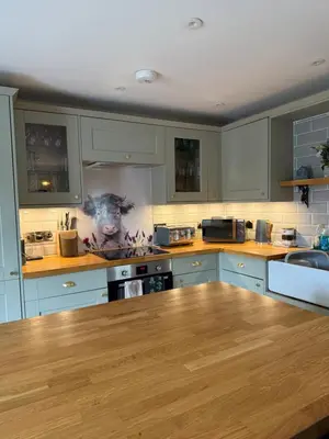 a kitchen with blue cabinets and a wooden counter top at Distillers Cottage, Peaceful rural retreat in Lanarkshire, onsite craft distillery, hot tub, bbq hut, central for exploring Scotland in Forth