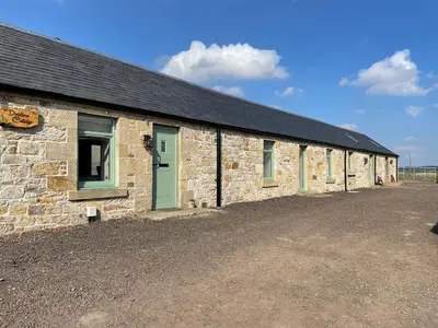 a stone building with green doors and a gravel driveway at Distillers Cottage, Peaceful rural retreat in Lanarkshire, onsite craft distillery, hot tub, bbq hut, central for exploring Scotland in Forth