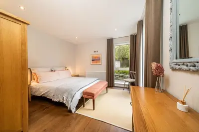 a bedroom with a bed and a window at Stables Cottage in Dunira