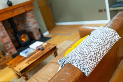 a living room with a couch and a fireplace at The Granary in Dunira