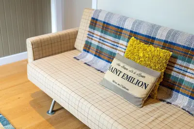 a couch with a blanket and pillows on it at The Granary in Dunira