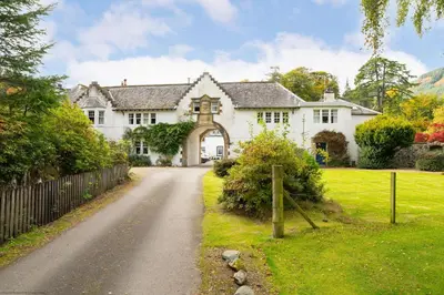 a large white house with a road in front of it at The Granary in Dunira