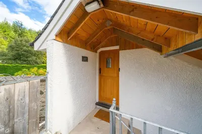 a porch of a house with a wooden door at The Granary in Dunira