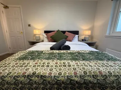 a bedroom with a large bed with a quilt on it at Luxury townhouse in Stirling in Stirling