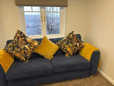 a blue couch with pillows on it with a window at Luxury townhouse in Stirling in Stirling