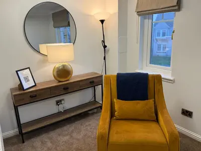 a living room with a yellow chair and a mirror at Luxury townhouse in Stirling in Stirling