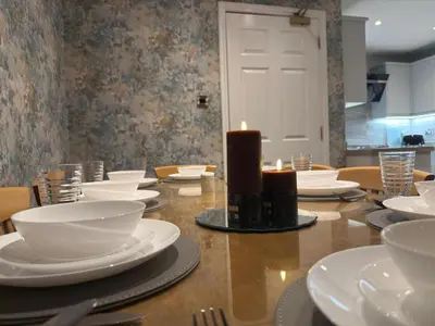 a table with white plates and a candle on it at Luxury townhouse in Stirling in Stirling