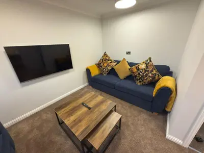 a living room with a blue couch and a tv at Luxury townhouse in Stirling in Stirling