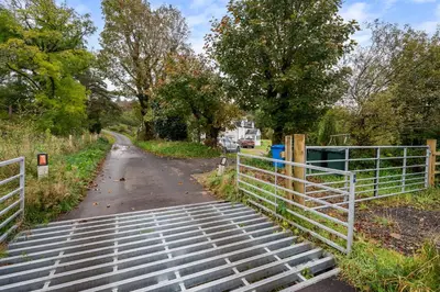 a gate on the side of a road at Stunning 2 Bed Riverside Cottage near Oban in Oban