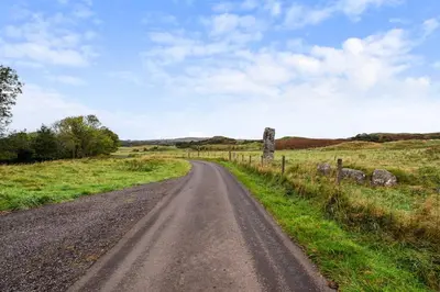 a dirt road in the middle of a field at Stunning 2 Bed Riverside Cottage near Oban in Oban