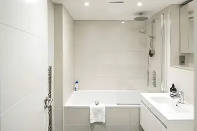 a white bathroom with a sink and a shower at 1 Bed Flat in Shoreditch near Station by Hostroo in Moffat