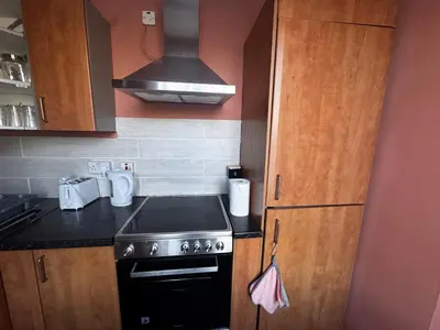 a small kitchen with a stove and a sink at 4BR Home near Airport & City Centre Free Parking in Edinburgh