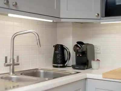 a kitchen counter with a sink and a coffee maker at Pass the Keys Spacious Bright Modern Edinburgh City Flat in Edinburgh