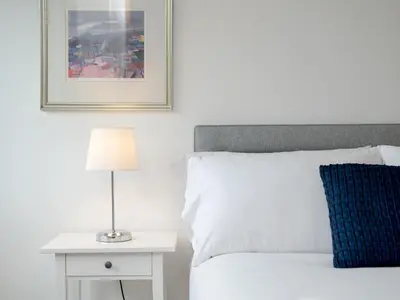 a bedroom with a bed and a table with a lamp at Pass the Keys Spacious Bright Modern Edinburgh City Flat in Edinburgh