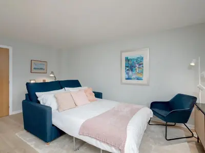 a bedroom with a blue bed and a blue chair at Pass the Keys Spacious Bright Modern Edinburgh City Flat in Edinburgh