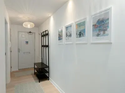 a hallway with white walls and pictures on the wall at Pass the Keys Spacious Bright Modern Edinburgh City Flat in Edinburgh