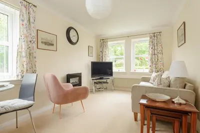 a living room with a couch and a tv at Lovely Edinburgh Home - Craighouse Gardens in Edinburgh
