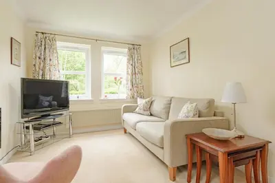 a living room with a couch and a tv at Lovely Edinburgh Home - Craighouse Gardens in Edinburgh