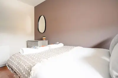 a bedroom with a white bed and a mirror at 4 BDR House By Caledonia Luxe Stays Short Lets & Serviced Accommodation Livingston in Livingston