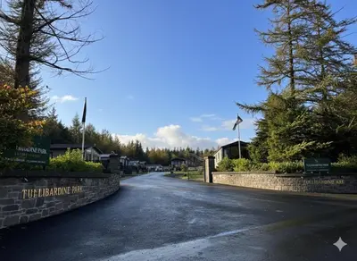 an empty road with a stone wall and trees at Luxury Lodge