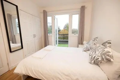 a white bed in a room with a window at Knightswood in Knightswood