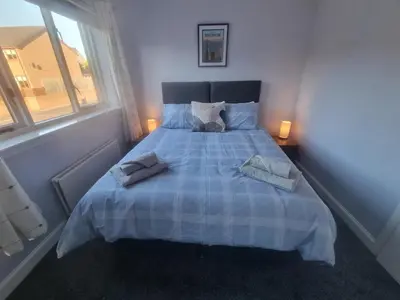 a bedroom with a bed with two towels on it at Cheerful two bedroom home in Dunfermline in Dunfermline