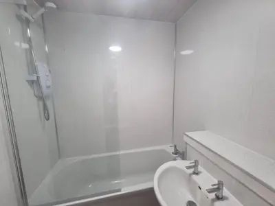 a white bathroom with a sink and a shower at Cheerful two bedroom home in Dunfermline in Dunfermline