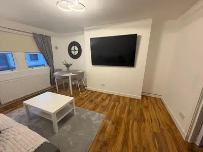 a living room with a flat screen tv on the wall at Premium Village Stay near Train & Loch in Lochwinnoch