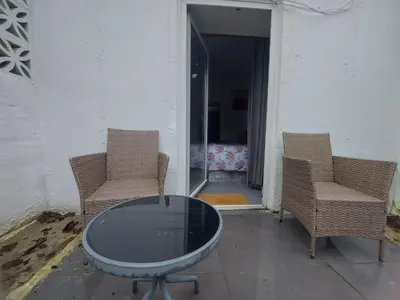 two chairs and a glass table on a patio at The Wee Nest in Largs - One-Bedroom Ground Flat in Largs