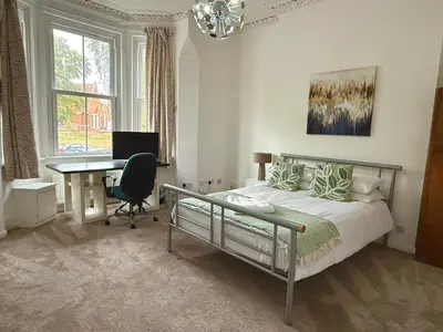 a bedroom with a bed and a desk and a computer at Clapham Road Apartment in Moffat