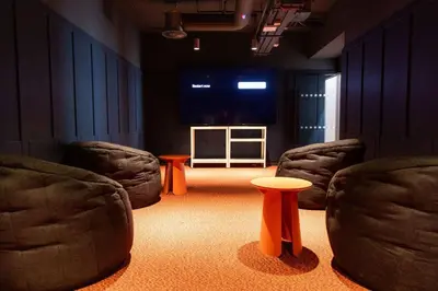 a room with two chairs and a table and a screen at For Students Only Martha Street Glasgow in Glasgow