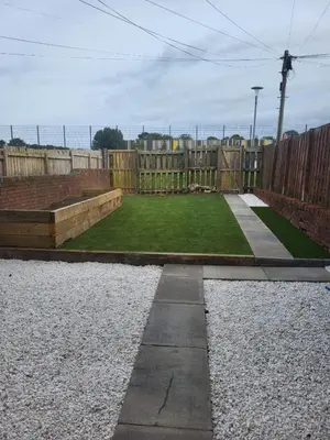 a garden with a wooden fence and a green lawn at The MacIntyre - Coorie Doon Stays in Kilmarnock
