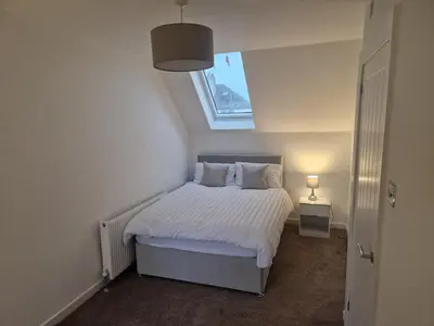 a small bedroom with a bed with a window at Edinburgh West Luxury 5 Bedroom Home in Edinburgh