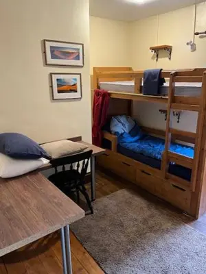 a room with a bunk bed with a bench and a table at The White Hart Inn & Bunkhouse in Moffat