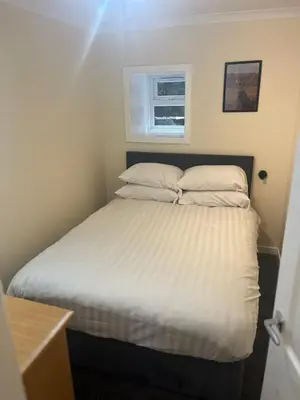 a bed with white sheets and pillows in a room at Flat in Oban town centre in Oban