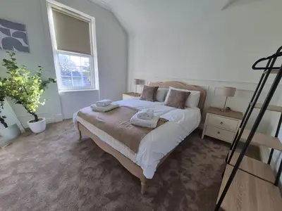 a bedroom with a bed with towels on it at Kirkgate 2 bed - Coorie Doon Stays in Irvine