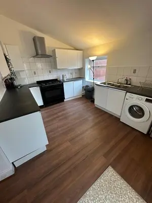 a kitchen with white cabinets and a washer and dryer at Victorian 5 Bedroom House Free Parking SSE Central in Glasgow