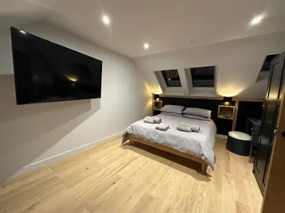 a bedroom with a bed and a large tv on the wall at 2-Bed - Sleeps 6 - Pet Friendly with Free Parking in Falkirk