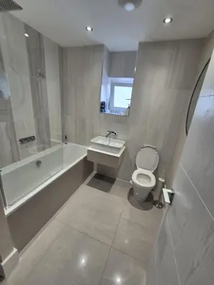 a bathroom with a tub and a toilet and a sink at Ardlui House Gardens in Hamilton