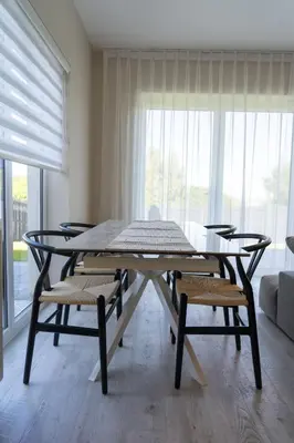 a table and chairs in a room with a large window at Ardlui House Gardens in Hamilton