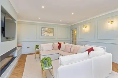 a living room with a white couch and a tv at The Kings Park Luxury Residence in Stirling