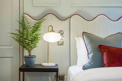 a bed with a lamp and a plant on a table at The Kings Park Luxury Residence in Stirling