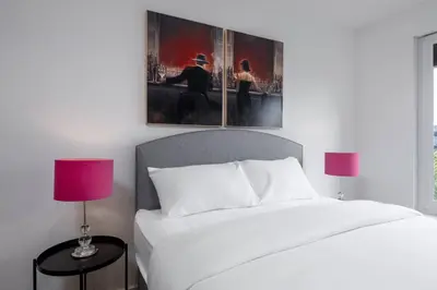 a bedroom with a bed and two paintings on the wall at The Stirling Penthouse - Free Parking in Stirling