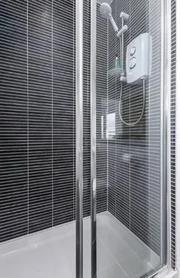 a shower with a glass door in a bathroom at The Stirling Penthouse - Free Parking in Stirling